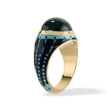 Load image into Gallery viewer, A gold ring with a dark blue green cabochon tourmaline bezel set gemstone top and a navy blue patterned enamel band accented with light blue tie dye details, shown on a white background.