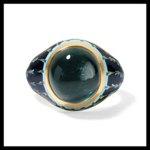 Load image into Gallery viewer, A vintage-style oval ring featuring a large dark green tourmaline cabochon bezel set gemstone, surrounded by a gold bezel and set in a dark blue enamel band decorated with light blue and gold floral patterns.